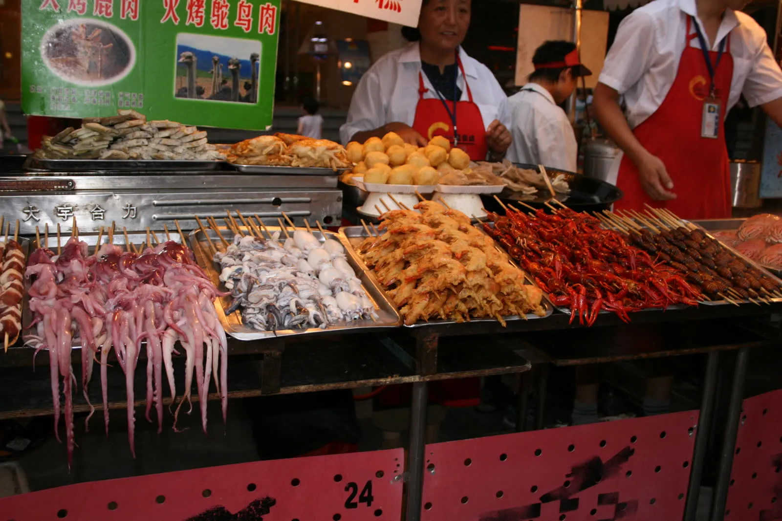 A Beijing street food market with stalls and customers at night