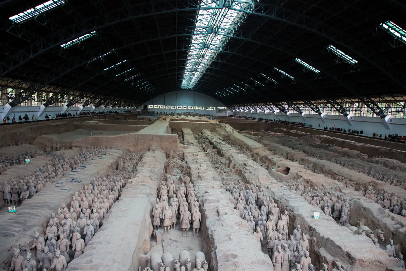 Close view of terracotta warrior figures in a restored row inside the pits